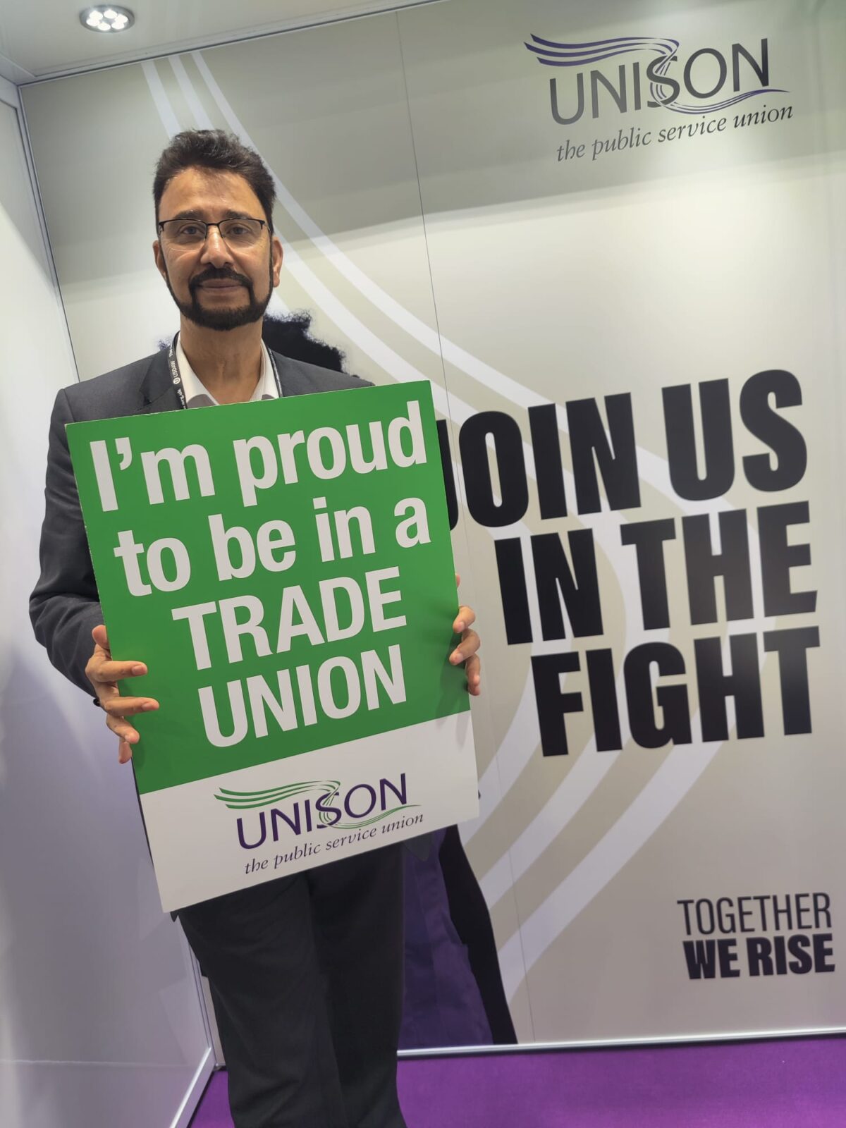 Afzal Khan MP holds a sign that says 