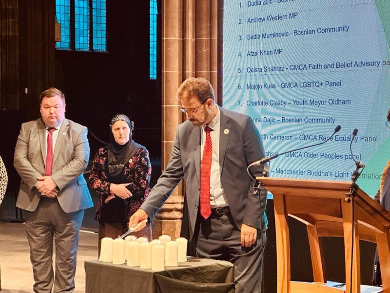 Afzal Khan MP lighting a candle at the Srebrenica Civic Remembrance Service at Manchester Cathedral