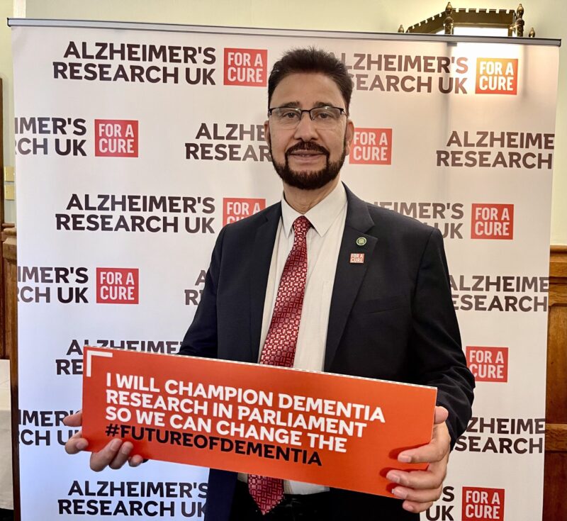 Afzal Khan MP holding a sign which reads "I will champion dementia research in Parliament so we can change the #FutureofDementia"